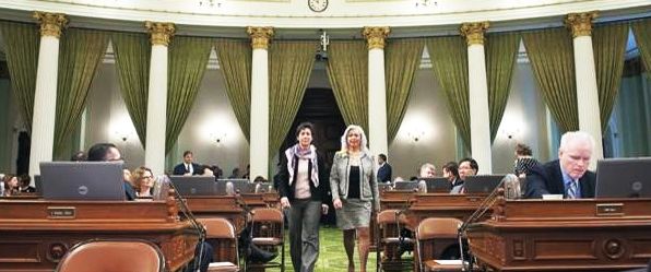 Assembly woman Susan Eggman, D-Stockton, left, accompanies Bonnie Lew down the aisle on the floor of the State Legislature in Sacramento.